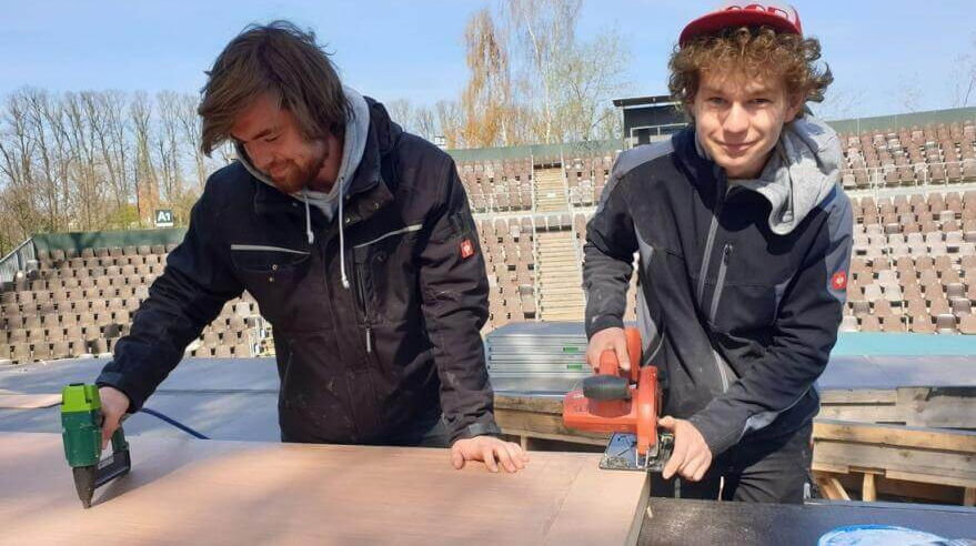Adrian Brombacher und Jasper Stöckel arbeiten am Aufbau der Bühne